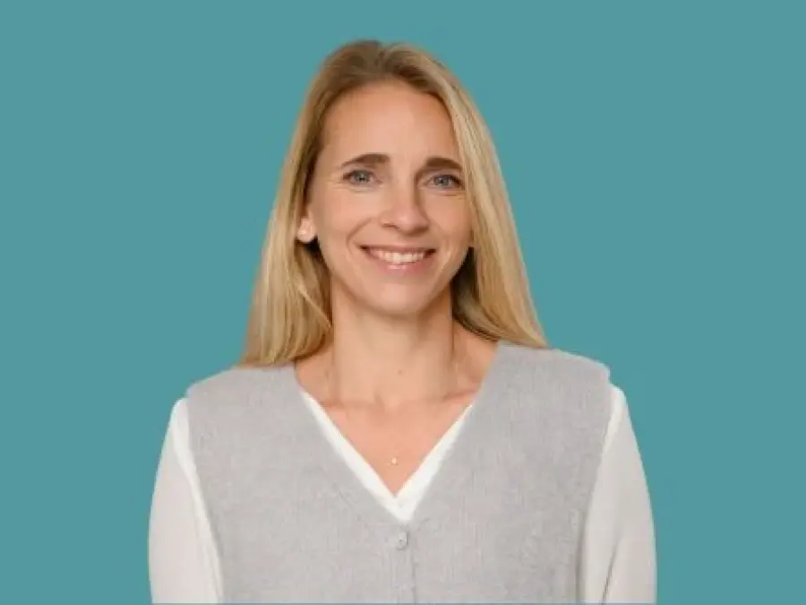 Portrait Anna Kriner, blonde lange Haare, wei&szlig;e Bluse und graue &auml;rmellose Weste