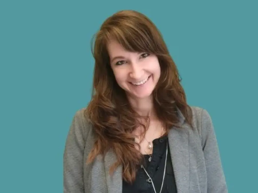 Portrait Manuela Kubesch, lange braune Haare, grauer Blazer, schwarzes Oberteil